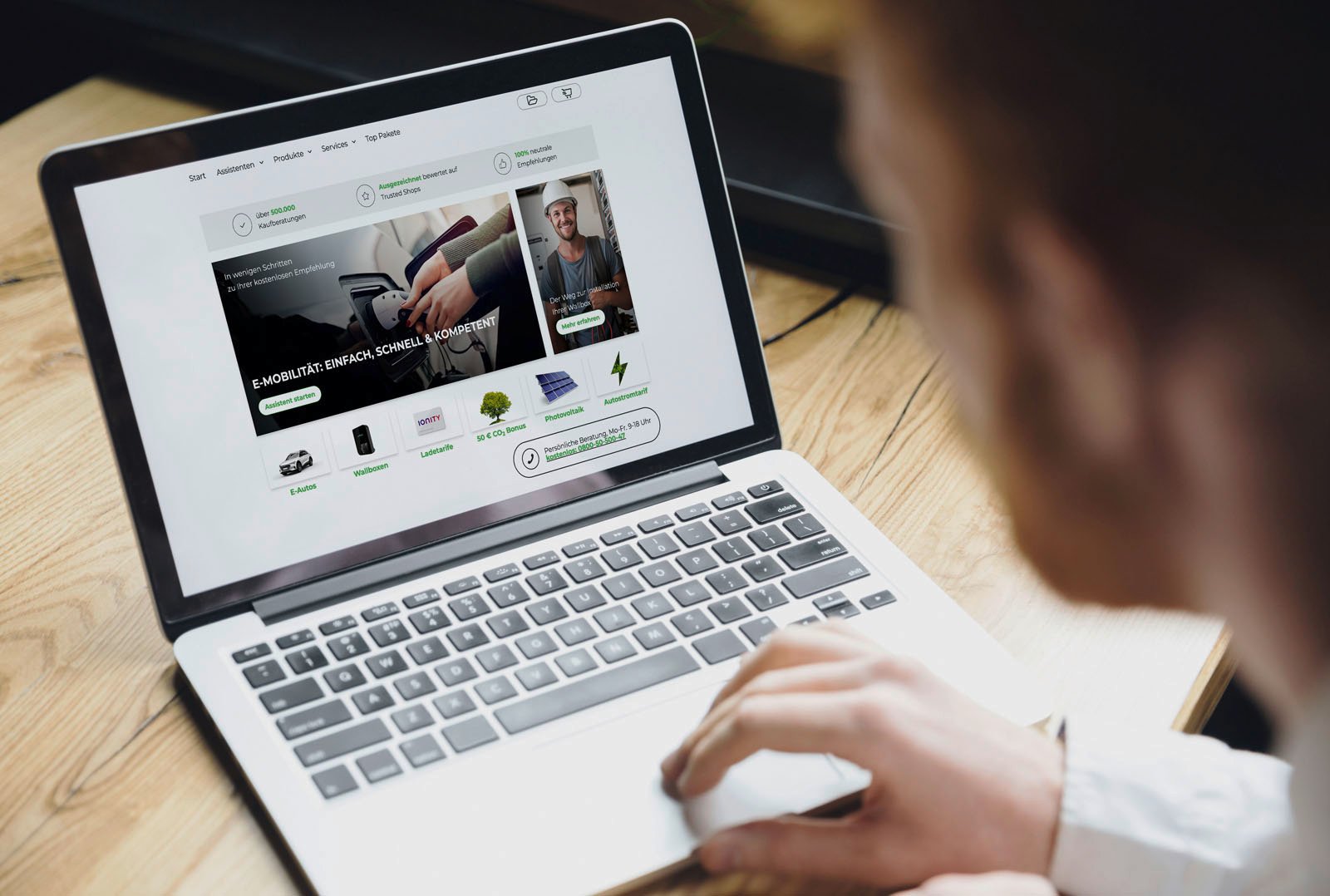 Person betrachtet den e-Kaufberater auf einem Laptop in moderner Arbeitsumgebung